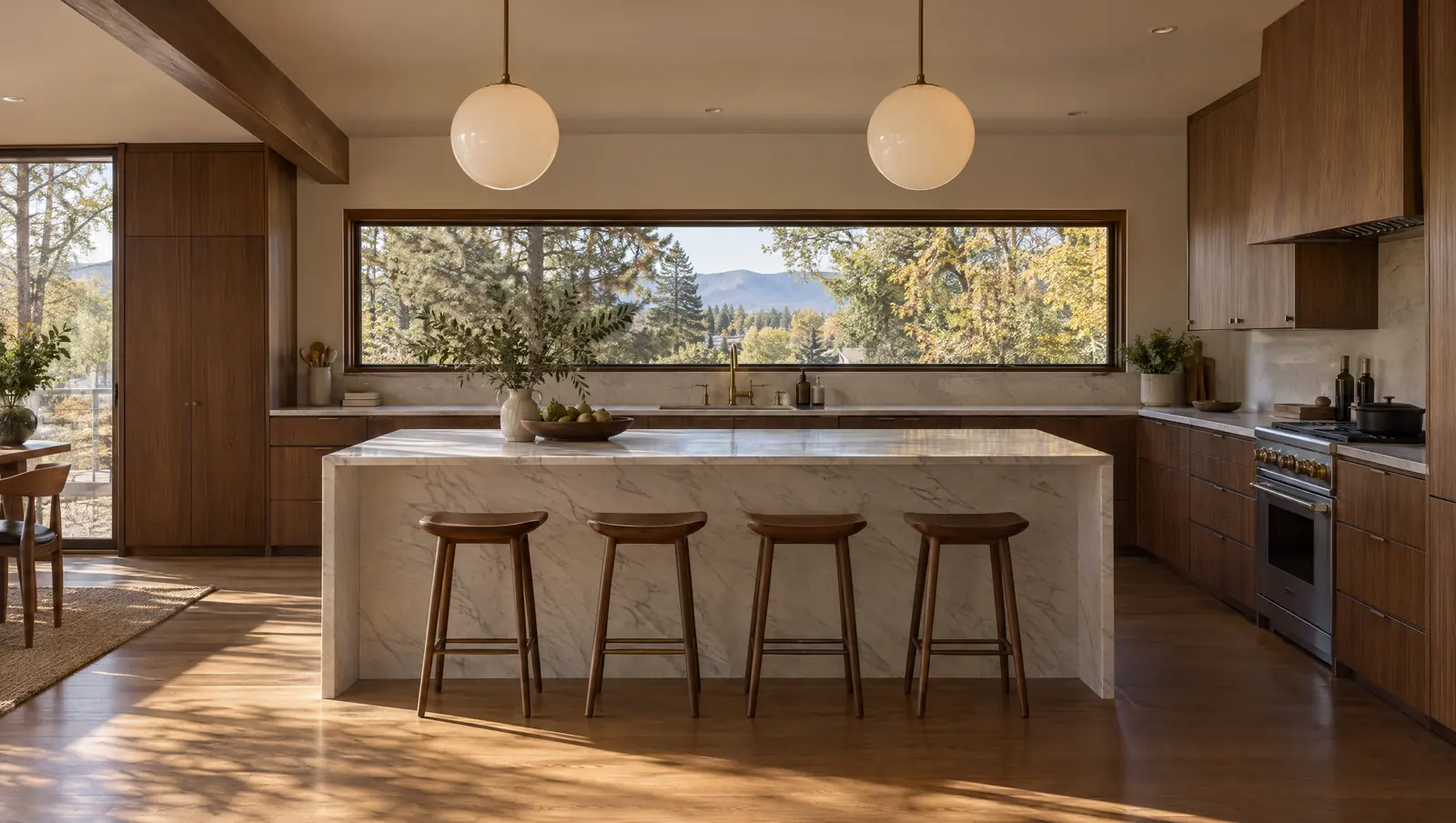 Concept renovated mid-century kitchen in Littleton with walnut cabinetry, a honed white marble island and globe pendants